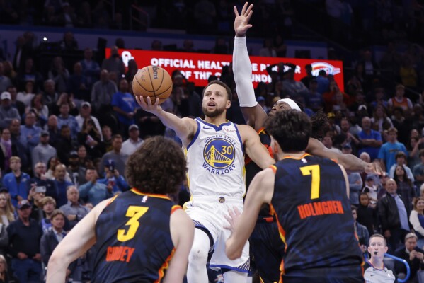 Người bảo vệ Golden State Warriors Stephen Curry (30) chuẩn bị sút, ghi bàn thắng vào rổ ở giây cuối cùng, khi người bảo vệ Oklahoma City Thunder Josh Giddey (3), tiền đạo Chet Holmgren (7) và người bảo vệ Luguentz Dort, hậu vệ phải, bảo vệ trong một pha cản phá Trận đấu bóng rổ trong mùa giải NBA vào Thứ Sáu, ngày 3 tháng 11 năm 2023, tại Thành phố Oklahoma. (Ảnh AP / Hóa đơn Nate)