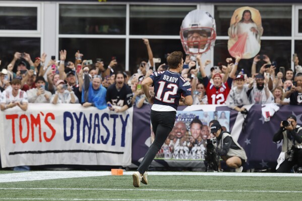 Former New England Patriots quarterback Tom Brady runs past fans during halftime ceremonies held to honor Brady at an NFL football game between the Philadelphia Eagles and the New England Patriots, Sunday, Sept. 10, 2023, in Foxborough, Mass. (AP Photo/Michael Dwyer)